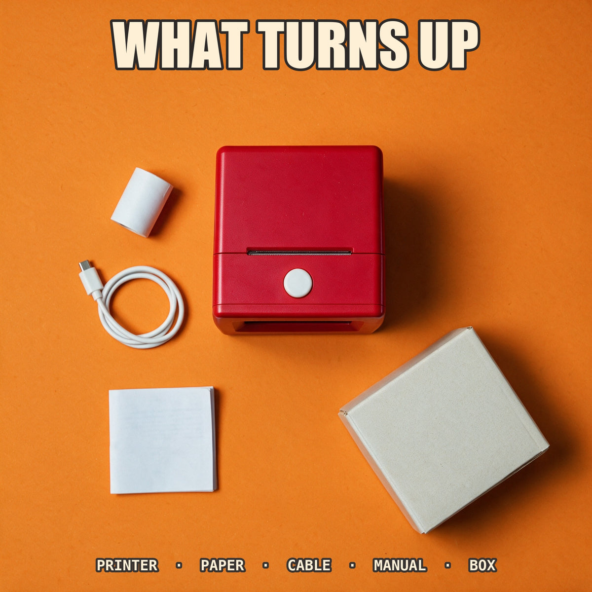 Flat lay of the printer, one paper roll, a USB cable, the manual and the box
